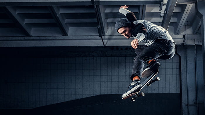 A skateboarder performing a trick in a spacious basement, capturing the essence of indoor skateboarding.