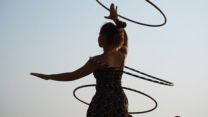 An individual showcasing impressive hula hooping skills, with multiple hoops spinning simultaneously.