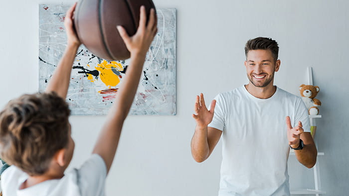 Players engaged in an intense indoor basketball match, showcasing the excitement of the game in a home setting.