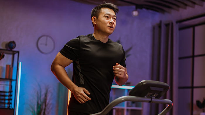 A motivated individual running on a treadmill, with a backdrop of a home setting and a determined expression.