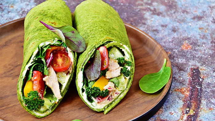 A spinach wrap filled with fresh vegetables